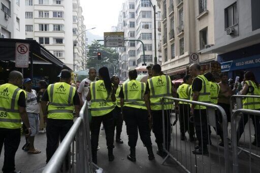Security personnel check fans as they access streets leading to Copacabana Beach ahead of Shakira's concert
